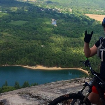 a person riding a motorcycle next to a body of water