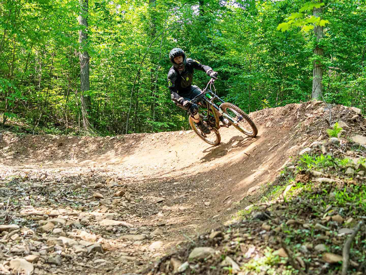 a man riding a bike down a dirt road